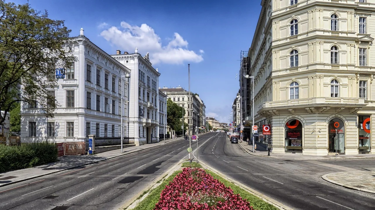 Ulica w centrum Paryża z zabytkowymi kamienicami, samochodami i kwiatami, klimat city break