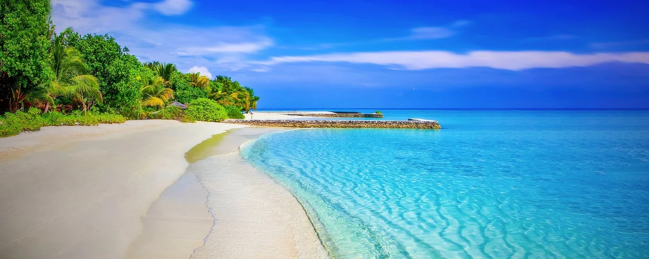 Piaszczysta plaża w Chorwacji z turkusową wodą i zieloną zatoką, idealna dla rodzin na spokojny wyjazd