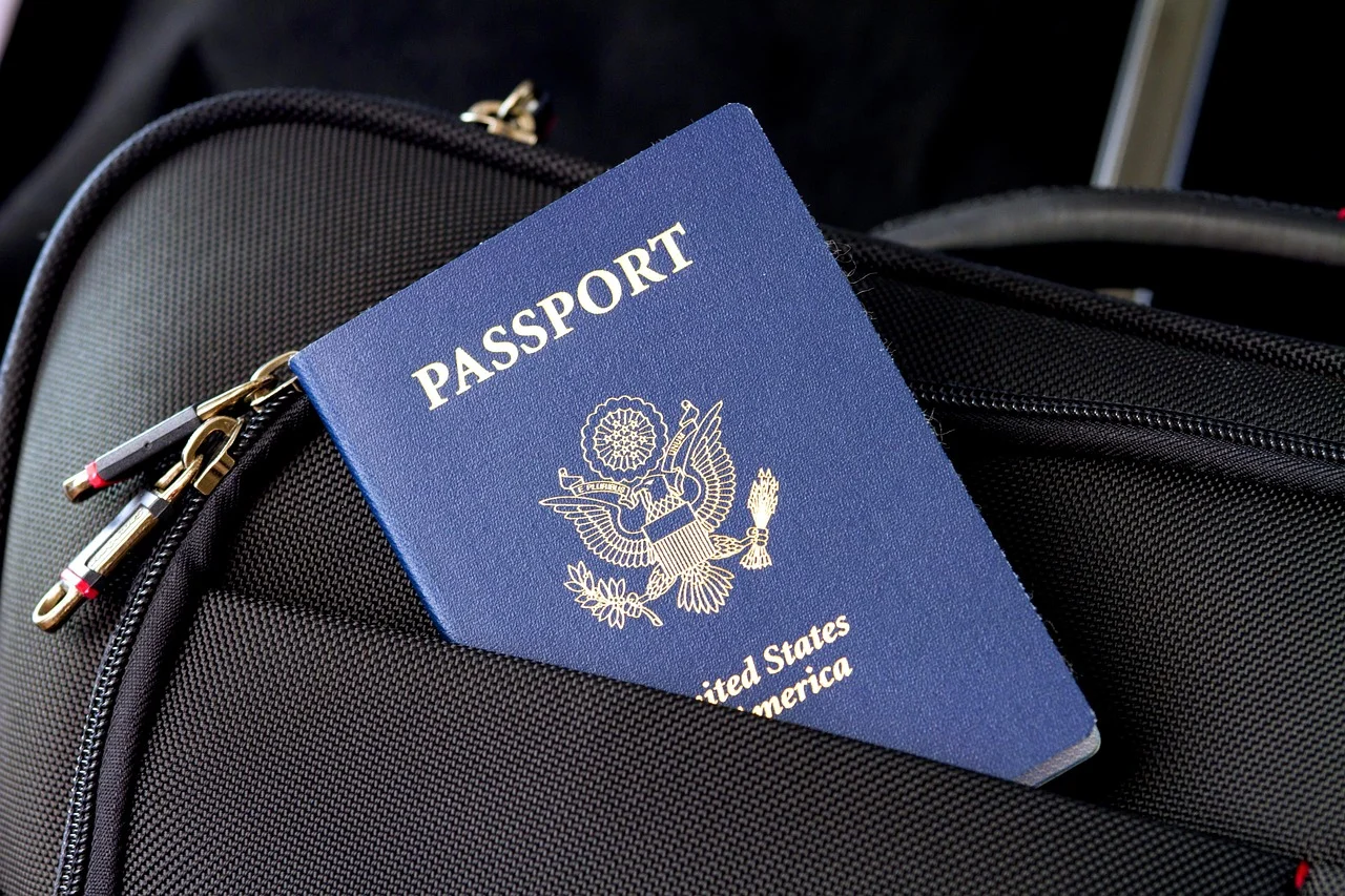 Paszport USA na tle walizki, przydatny do wizy i przygotowania wniosku bez stresu