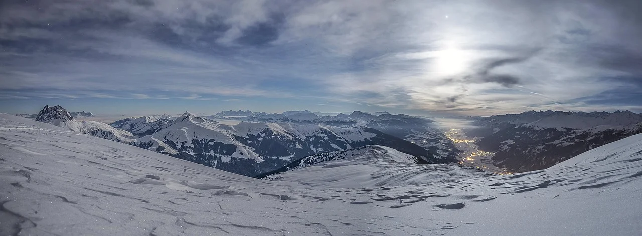 Alpejska panorama o świcie: ośnieżone stoki i dolina, inspiracja do ferii w Alpach